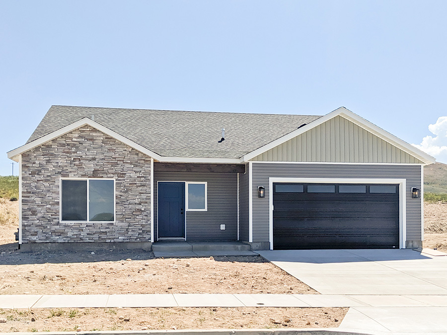 Charming Brown home with covered front porch, gable roof, and 2-car garage